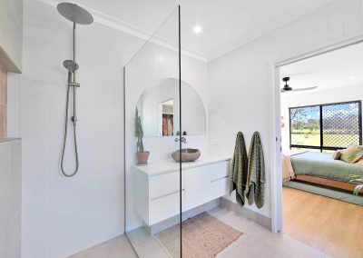 Ensuite with walk-in shower and stone basin, looking into a bedroom