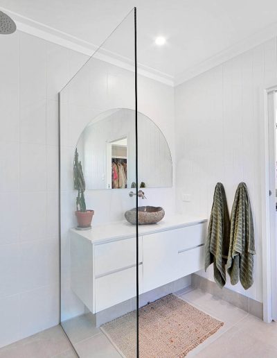 Ensuite with walk-in shower and stone basin, looking into a bedroom