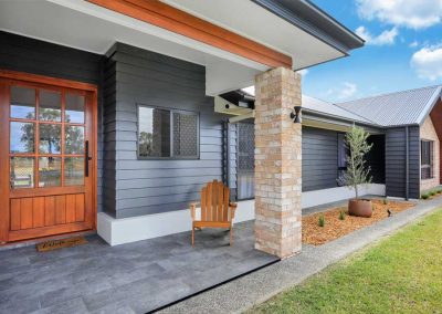 Front entry with timber door, brick pillar and dark cladding