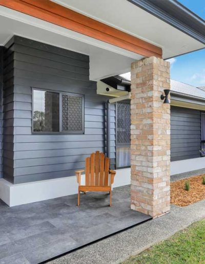 Front entry with timber door, brick pillar and dark cladding