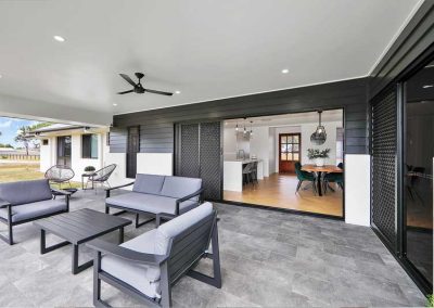 Covered alfresco with outdoor lounge set and sliding doors into the dining room