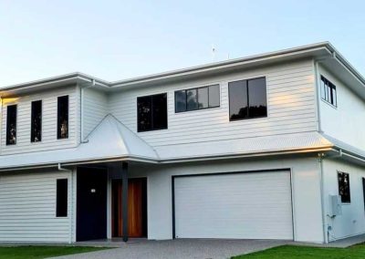 Two-storey white weatherboard house with a double garage