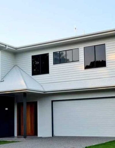 Two-storey white weatherboard house with a double garage