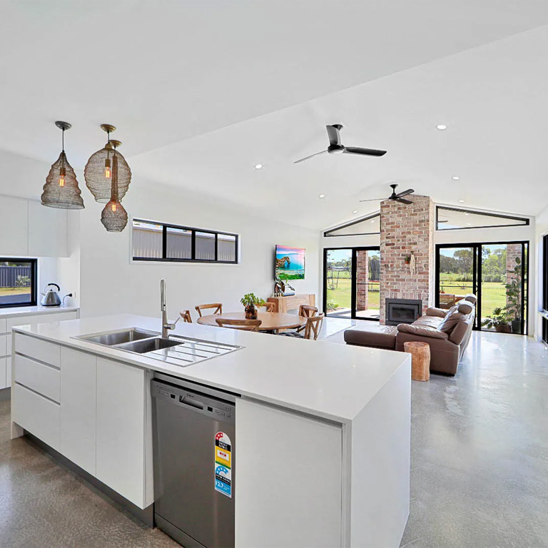 Open-plan kitchen and living area with brick fireplace and polished concrete floor