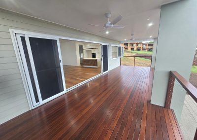 Covered timber deck alongside glass sliding doors