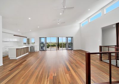 Open living area with timber floors and glass doors to a view